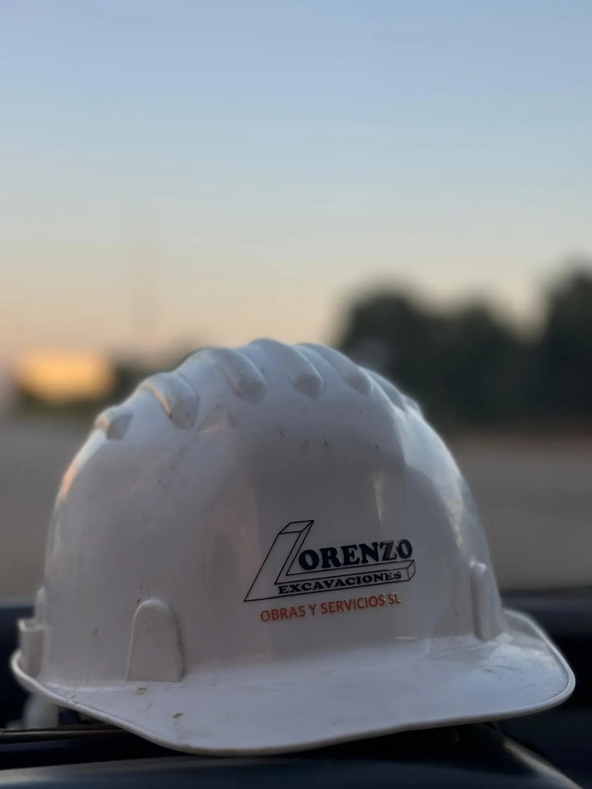 Casco de obra de Lorenzo Excavaciones en primer plano