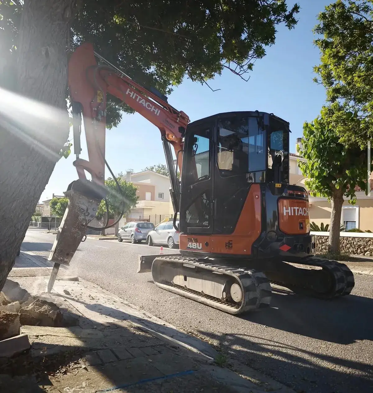 Hitachi ZAXIS 48U mini-excavator breaking a pavement with a hydraulic hammer